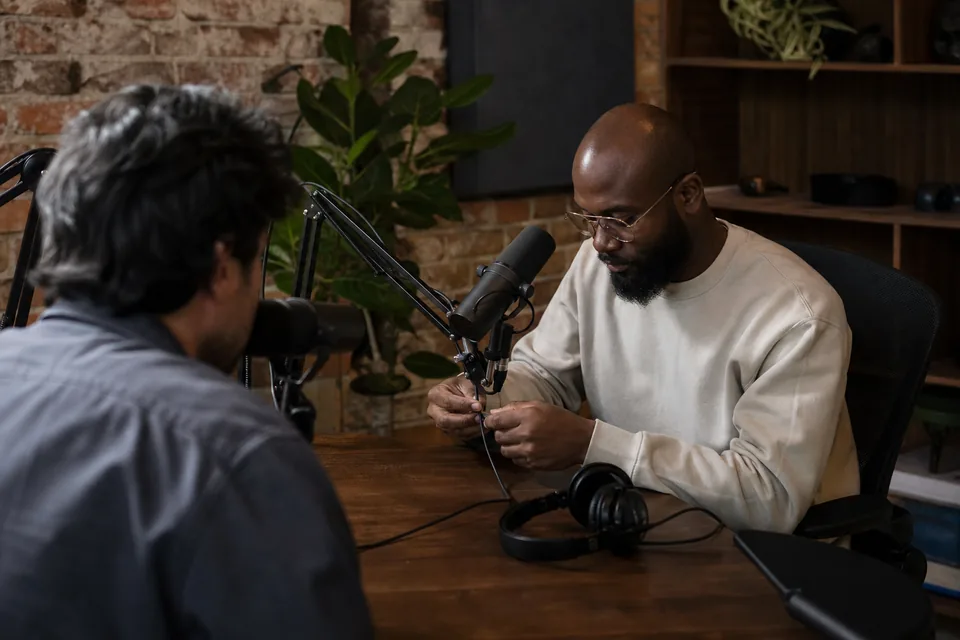 Podcast host speaking into a microphone in a small home studio