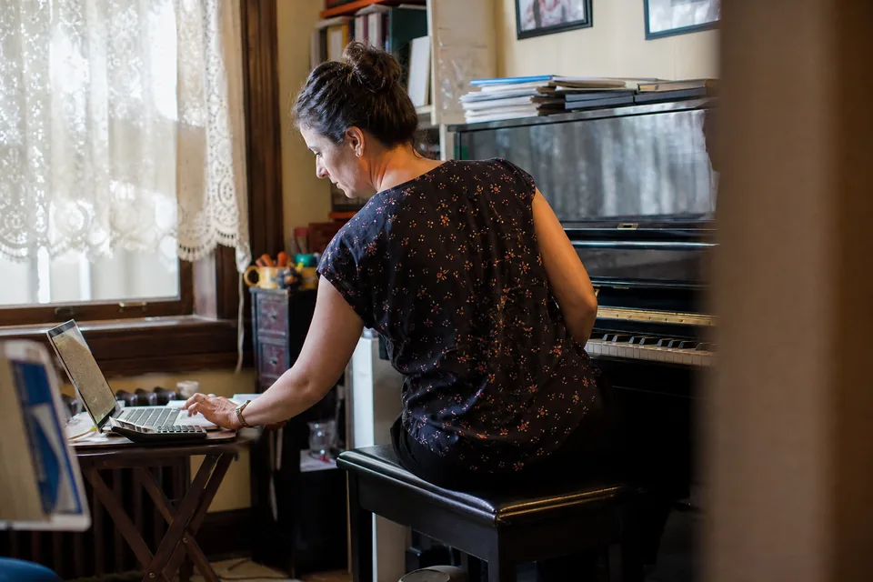 A music teacher checking monthly income at a home desk