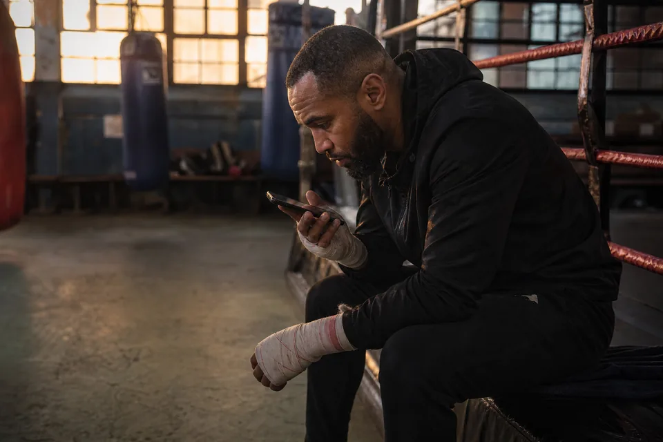 A trainer replying to member messages on a gym bench
