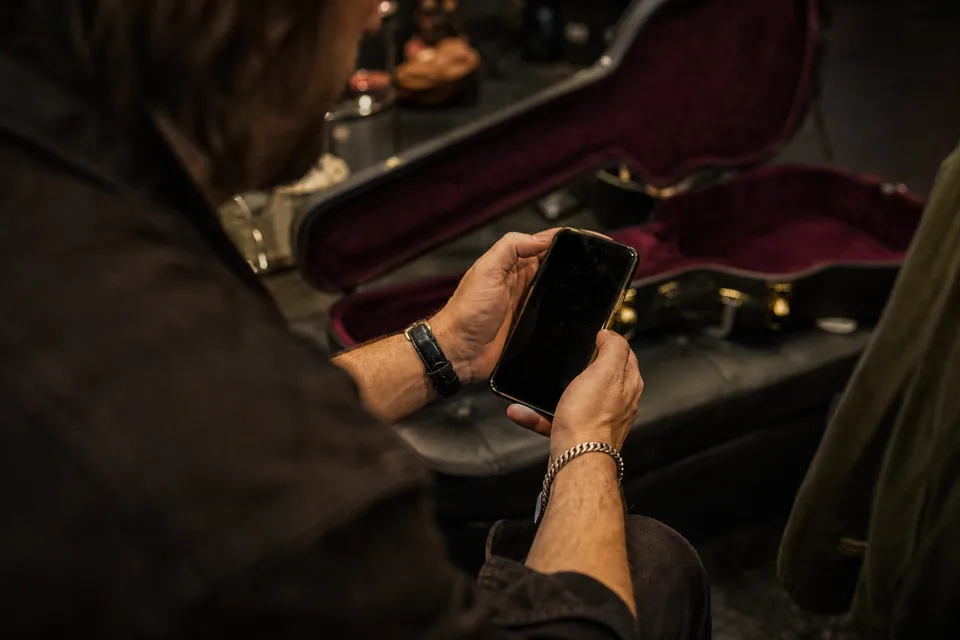 Creator sharing a link with fans from a phone backstage